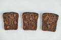 Slices of fresh brown bread with raisins on a white wooden background. Top view. Copy, empty space for text Royalty Free Stock Photo