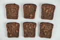 Slices of fresh brown bread with raisins on a white wooden background. Top view. Copy, empty space for text Royalty Free Stock Photo