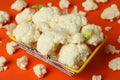 Slices of fresh juicy cauliflower in basket on orange background Royalty Free Stock Photo