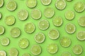 Slices of fresh juicy limes on green background Royalty Free Stock Photo