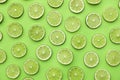 Slices of fresh juicy limes on green background Royalty Free Stock Photo