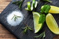 Slices of fresh lime, salt and rosemary on a wooden cutting Board Royalty Free Stock Photo