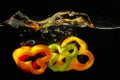 Slices of fresh peppers falling in water Royalty Free Stock Photo