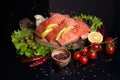 Slices of fresh salmon on a cutting wooden board with lemon slices, onions, cherry tomatoes on a twig, green olives, lettuce Royalty Free Stock Photo