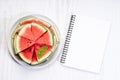 Slices of fresh watermelon with notebook paper on white wooden background Royalty Free Stock Photo