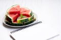 Slices of fresh watermelon with notebook paper on white wooden background Royalty Free Stock Photo