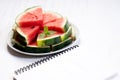 Slices of fresh watermelon with notebook paper on white wooden background Royalty Free Stock Photo