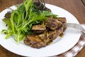 Slices of fried liver, green leaves of salads