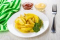 Slices of fried potatoes, napkin,bowls with ketchup and mayonnaise