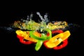 Slices of green, red and yellow pepper falling in water Royalty Free Stock Photo