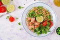Slices of grilled salmon, quinoa, green peas, tomato, lime and lettuce leaves. Flat lay. Top view Royalty Free Stock Photo