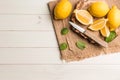 Slices, half fresh juicy lemon with mint leaves and knife on the vintage wooden table Royalty Free Stock Photo