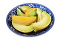 Slices of honeydew melon in a blue antique bowl isolated on whit