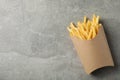 Slices of hot french fries in box on background, space for text. Top view Royalty Free Stock Photo