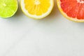 Slices of juicy organic ripe citrus fruits lemon lime grapefruit arranged as stoplight on white marble stone background. Creative