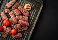 Slices of juicy steak with cherry tomatoes on grill pan. Royalty Free Stock Photo