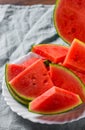 Slices of juicy watermelon on white plate on wooden table Royalty Free Stock Photo