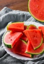 Slices of juicy watermelon on white plate on wooden table Royalty Free Stock Photo