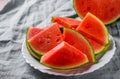 Slices of juicy watermelon on white plate on wooden table Royalty Free Stock Photo