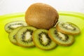Slices of kiwi fruits and whole kiw on cutting board on table Royalty Free Stock Photo