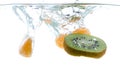 Slices of kiwi and mandarin thrown into the water. View from under the water Royalty Free Stock Photo