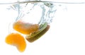 Slices of kiwi and mandarin thrown into the water. View from under the water Royalty Free Stock Photo