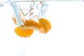 Slices of kiwi and mandarin thrown into the water. View from under the water Royalty Free Stock Photo