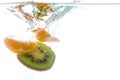 Slices of kiwi and mandarin thrown into the water. View from under the water Royalty Free Stock Photo