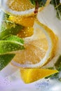 Slices of lemon and lime with bubbles of water in a glass. Macro photo of refreshing lemonade Royalty Free Stock Photo