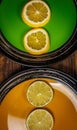 Slices of lime and lemon on yellow and green plates on a wooden surface Royalty Free Stock Photo