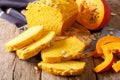 Slices and loaf of freshly homemade pumpkin bread on wooden cutting board close-up. Horizontal