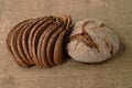 Slices and loaf of rye bread on burlap