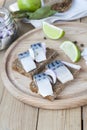 Slices of marinated mackerel with onion in a jar, lime, laurel and bread on wooden board Royalty Free Stock Photo