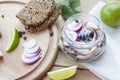 Slices of marinated mackerel with onion in a jar, lime, laurel and bread on wooden board Royalty Free Stock Photo