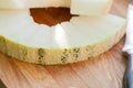 Slices of melon close-up and knife lying on a wooden board Royalty Free Stock Photo