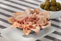 slices of mortadella on a plate. Italian sausage on a white table with a napkin. serving meat delicacy.