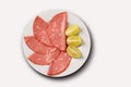 Slices of mortadella served with lemon on a white plate. top view Royalty Free Stock Photo