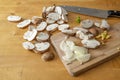 Slices of mushrooms, onion, chopped ginger and a kitchen knife on a wooden cutting board, cooking a healthy vegetarian dish, copy Royalty Free Stock Photo