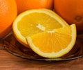 Slices of orange closeup on background of whole oranges Royalty Free Stock Photo