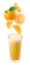 Slices of orange fall into a glass of fresh juice.