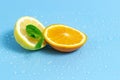 Slices of orange and lemon with mint leaves on a blue background with water drops. Summer cool water orange slices Royalty Free Stock Photo