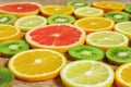 Slices of oranges, lemons, kiwi, grapefruit pattern  on wooden background. Fruit summer background Royalty Free Stock Photo