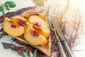 Slices of peaches lie on a plate of olive tree on a white table Royalty Free Stock Photo