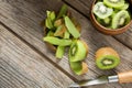 Slices and pealed kiwi on wooden table