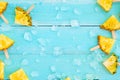 Slices pineapple popsicle sticks with ice on wood plank blue color. Royalty Free Stock Photo