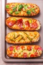 Slices of Pizza on bread with cheese and ingredients such as salami, prosciutto, ham. Flat lay, rustic style Royalty Free Stock Photo