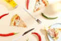 Slices of pizza, ingredients and cutlery on a white background. Top view Royalty Free Stock Photo