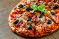 Pizza with Mozzarella cheese, salami, pepper, ham, pepperoni, olives, Spices and Fresh Basil. Italian pizza on wooden background Royalty Free Stock Photo