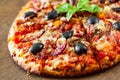 Pizza with Mozzarella cheese, salami, pepper, ham, pepperoni, olives, Spices and Fresh Basil. Italian pizza on wooden background Royalty Free Stock Photo