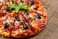 Pizza with Mozzarella cheese, salami, pepper, ham, pepperoni, olives, Spices and Fresh Basil. Italian pizza on wooden background Royalty Free Stock Photo
